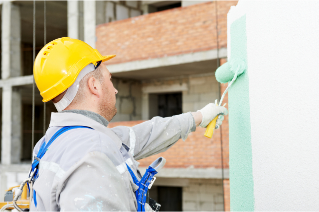 Commercial painter rolling paint on exterior wall